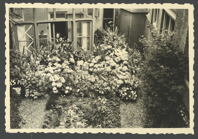 860297 Afbeelding van een bloemenzee in de achtertuin van de woning van Hendrik de Vos, directeur van Van Rijn's ...